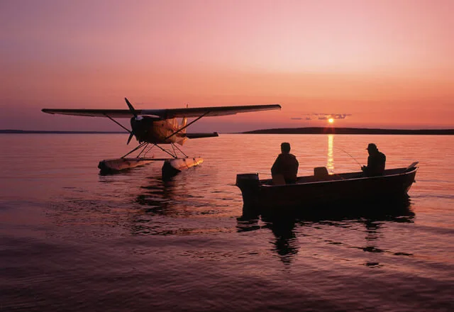 Gruppenreisende auf einem See in Kanada neben einem Wasserflugzeug